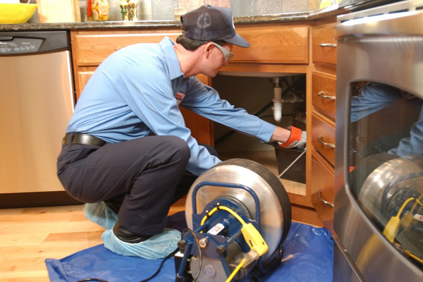 man cleaning drain in Allen home